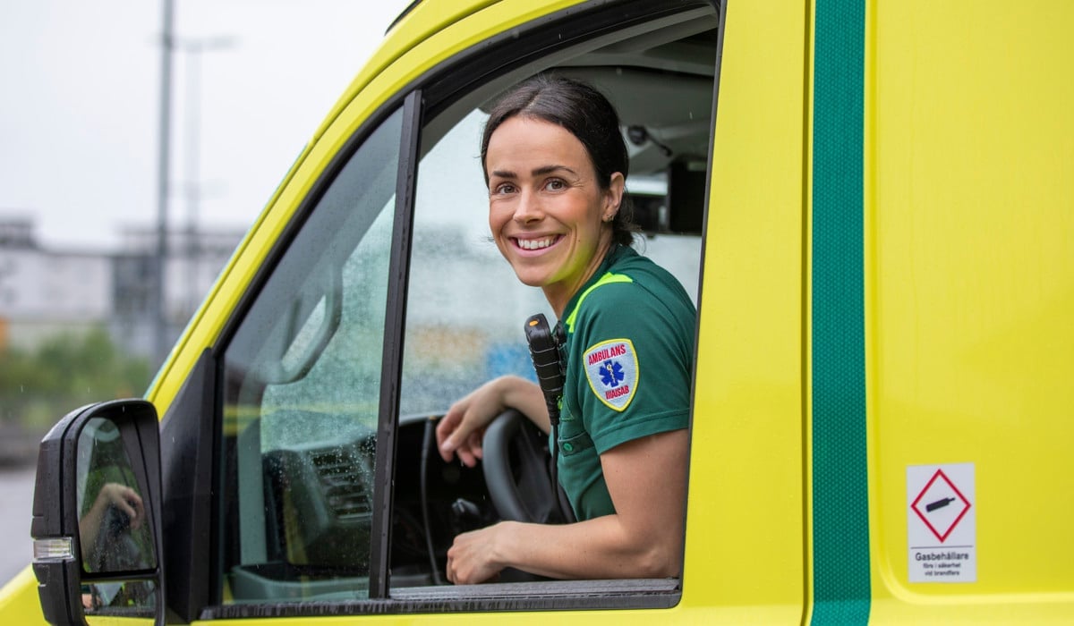 Ambulansmedarbetare tittar ut från förarhytten på en ambulans