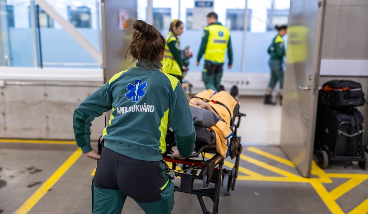 En kvinna som skjuter en vagn full med bagage.