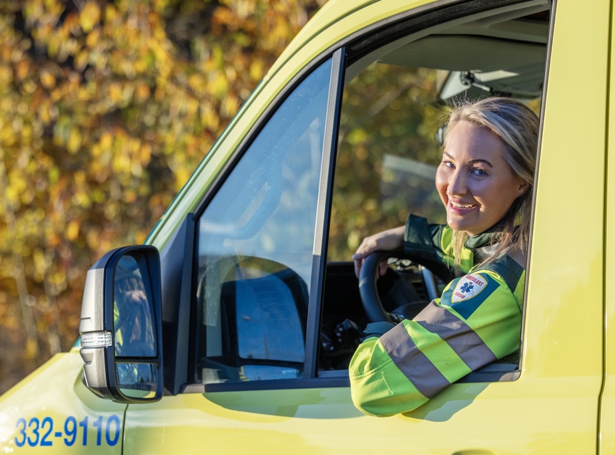 Sjuksköterska tittar ut från förarhytten på en ambulans