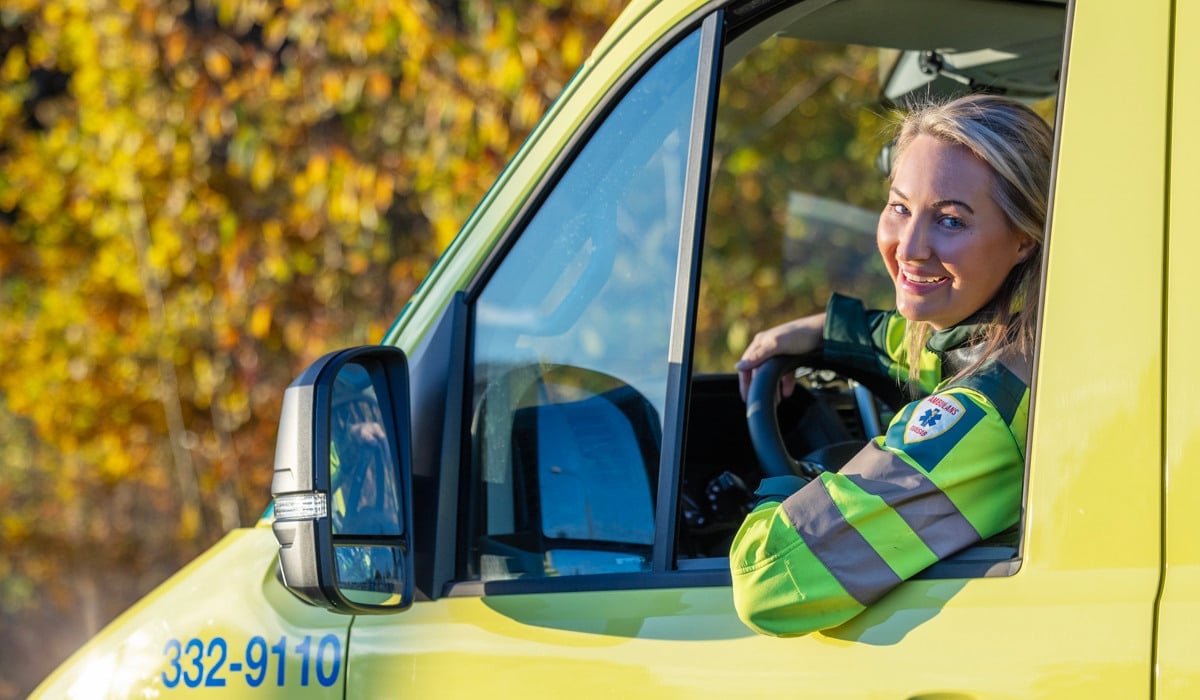 Sjuksköterska tittar ut från förarhytten på en ambulans