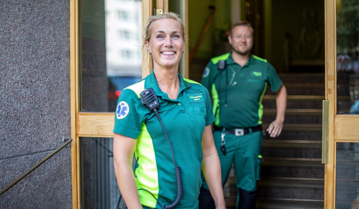 Två ambulansmedarbetare står i dörröppningen till trapphus