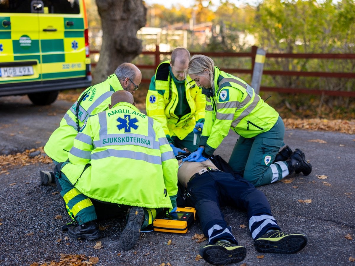 Ambulansmedarbetare som låtsas behandla patient med hjärtstopp