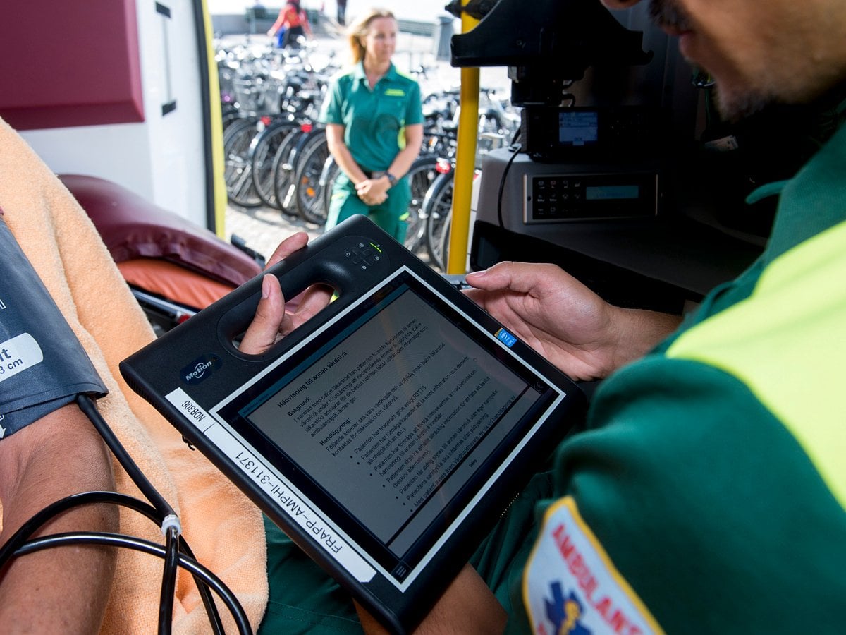Medarbetare i ambulans skriver i patientjournal